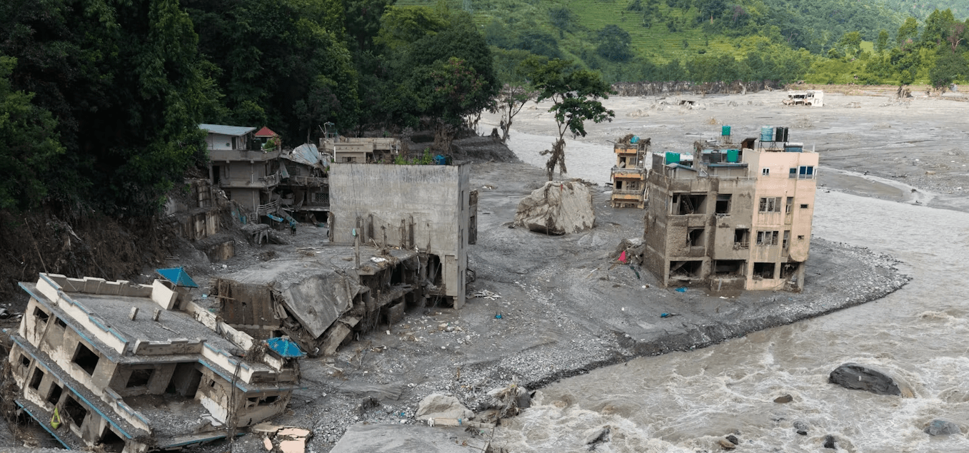 Buildings destroyed beside a swollen river in the flood-affected area of Nepal.